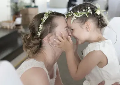 Braut lacht mit ihrer Tochter am Hochzeitstag