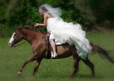 Spektakuläres Hochzeitsfoto: Braut reitet auf Pferd.