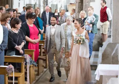 Hochzeitsfotograf fängt die Stimmung beim Einzug in die Kirche ein.