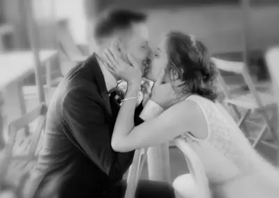Hochzeitsfoto in Schwarz Weiß: Brautpaar küsst sich.